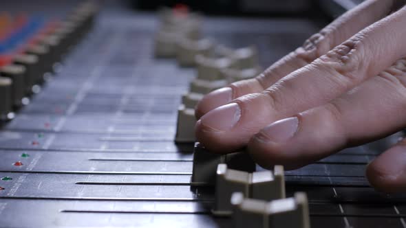 Faders Sliding Under Fingers of Record Producer