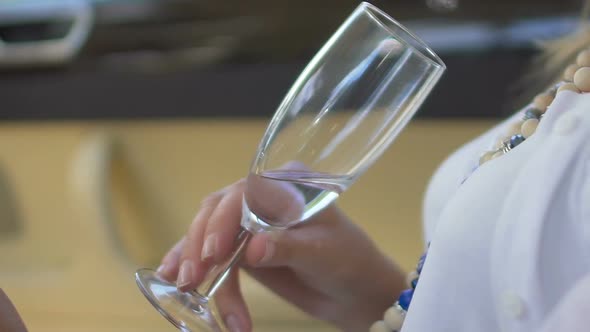 Closeup of Female Hand Holding Glass of White Wine, Relaxed Woman Enjoying Rest