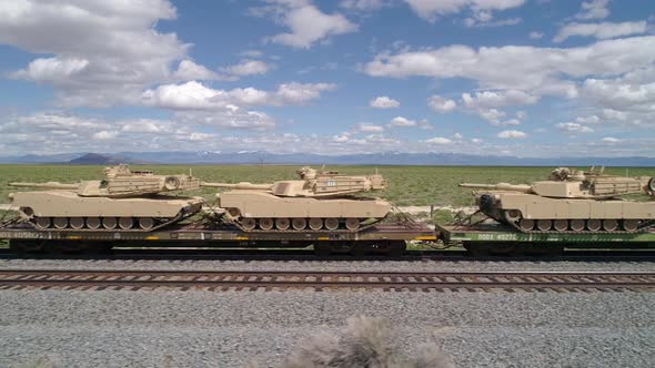 Panning view of military tanks loaded on train