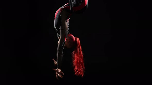 Pedestal Shot of Slim Flexible Woman Hanging Upside Down on Air Hoop Spinning in Slow Motion