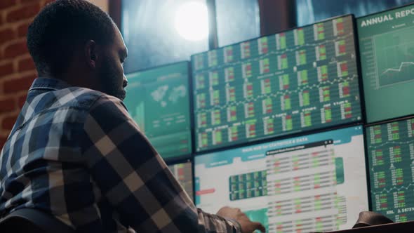 Bank Trader Analyzing Stock Market Statistics on Multi Monitors