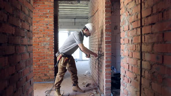 Worker is cutting wires with lineman's pliers.