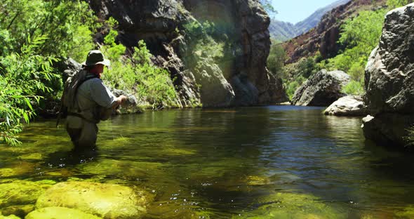 Fisherman fly fishing in river