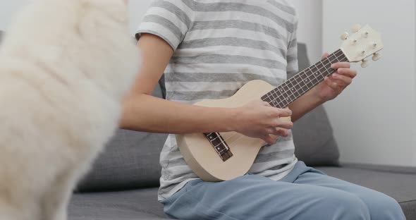 Woman play a song with Pomeranian dog 