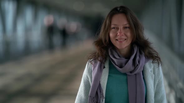 Portrait of a Confident and Cheerful Middle-aged Brown-haired Woman Who Is Standing in a Crowded