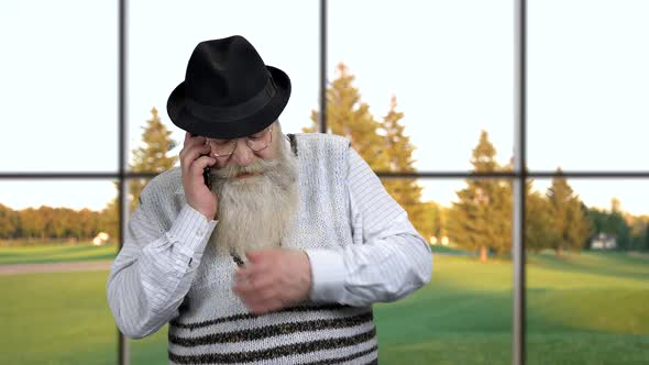 Old Bearded Man Talking on Cell Phone.