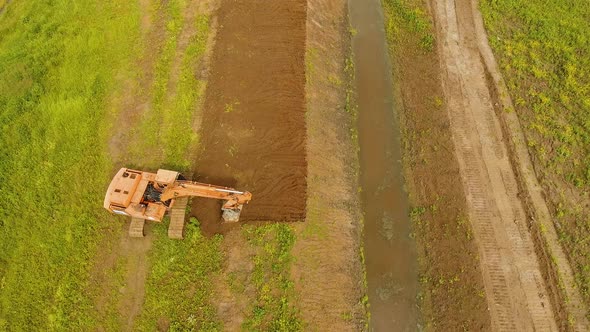 Excavator Digging a Trench in the Field