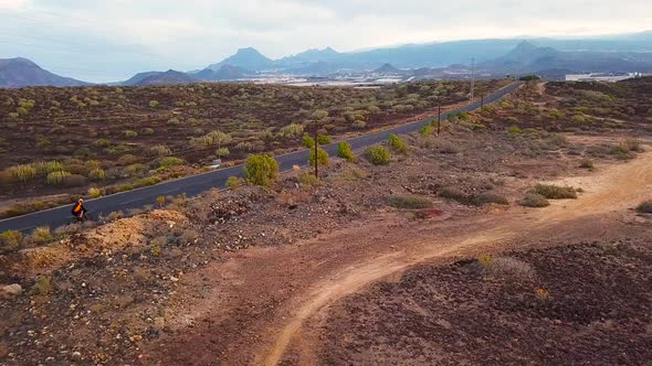 Aerial View of Cyclist Rider Traveling Up a Desert Road