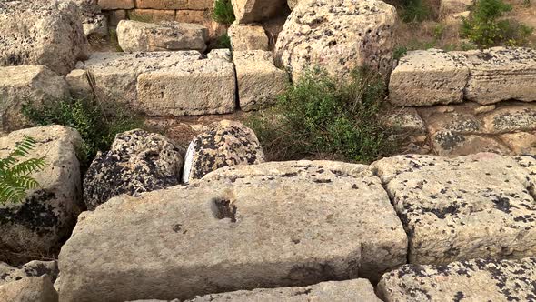 Tilt-up from ancient sundial engraved in rock to Greek temple at Selinunte archaeological park in Si