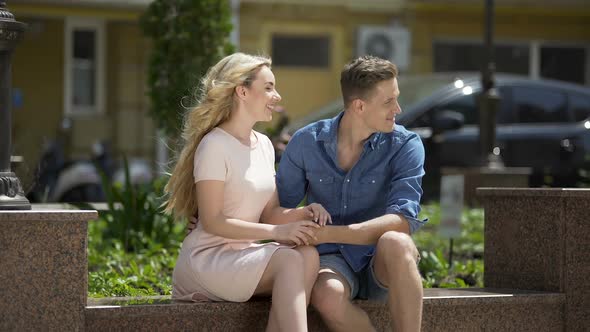 Girlfriend and Boyfriend Sitting on Bench Holding Hands, Talking, Relationship