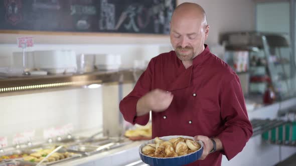 Positive Cook Bragging Ukrainian Cottage Cheese Pancakes Syrniki Standing in Cafeteria Gesturing