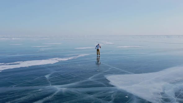 Aerial View of Man Skating on Lake Baikal Covered By Ice