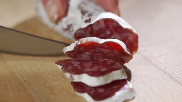 Hand Expert Cuts Parma Seasoned Salami, Thinly Sliced with a Knife and Emanates the Taste and the