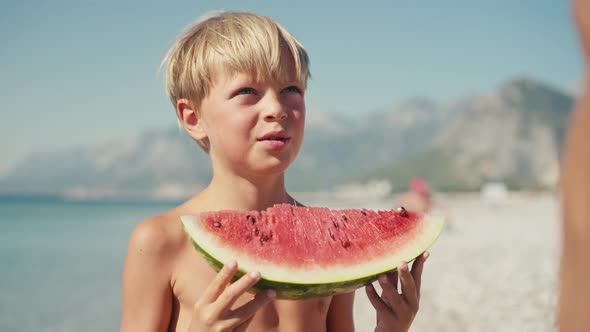 Boy Eating Watermelon on the Beach Summertime