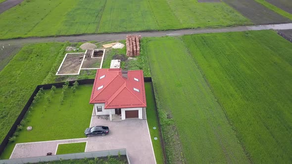 Aerial view of a private house and a yard with fence around.