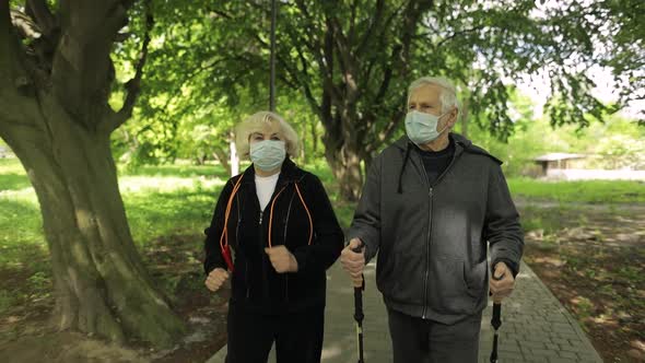 Active Senior Old Man, Woman Training Nordic Walking in Park During Quarantine