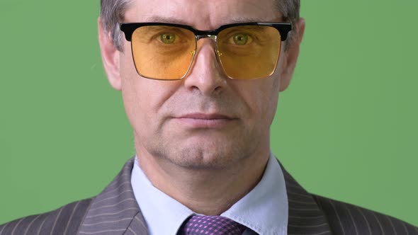 Mature Handsome Businessman Against Green Background