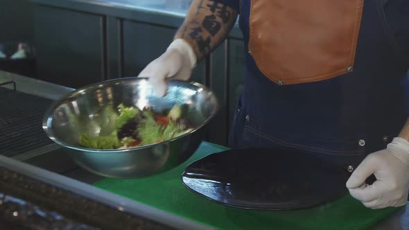 Cropped Shot of a Chef Putting Salad on a Plate