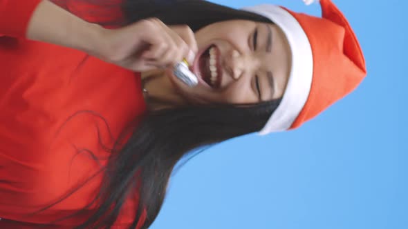 Young Woman Partying in Santa Hat with Party Horn