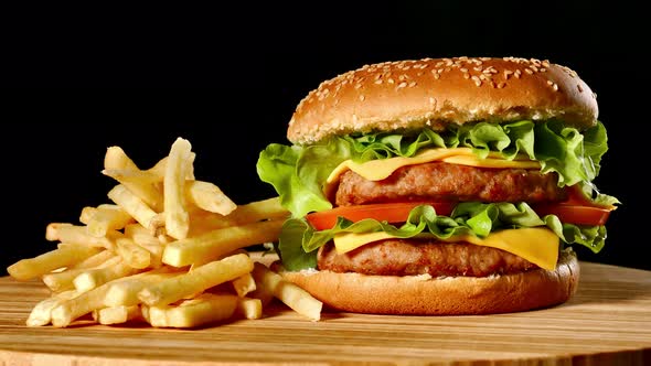 Craft Beef Burger and French Fries on Wooden Table Isolated on Black Background