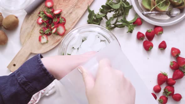 Step by step. Preparing organic infused water in glass beverage drink dispenser.