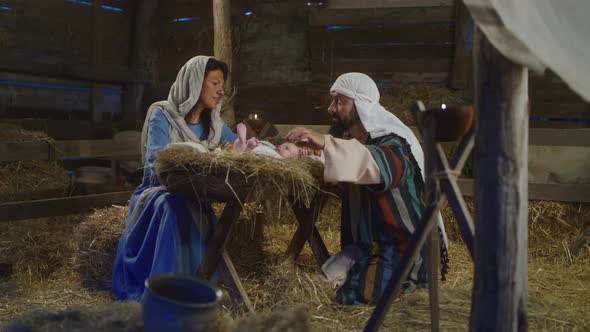 Mary and Joseph Speaking and Taking Care of Baby Jesus