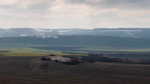 Time lapse with fast-moving clouds over an empty winter field