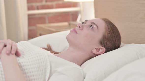 Worried Redhead Young Woman Trying To Sleep in Bed 