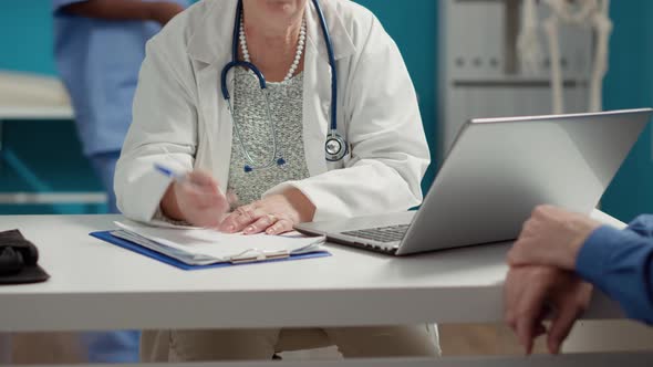 General Practitioner Taking Checkup Visit Notes on Documents