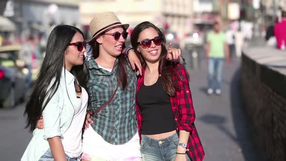 Three happy women walking in the city