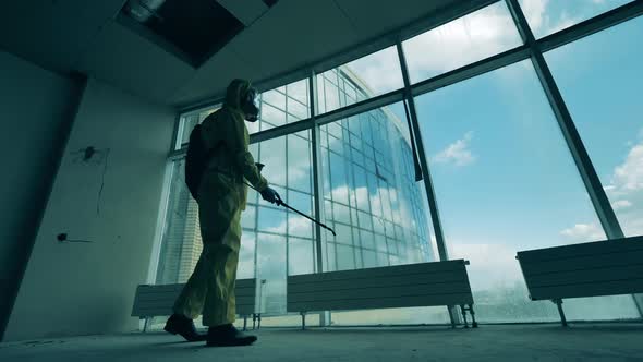 Male Worker Disinfects Room with a Sprayer.