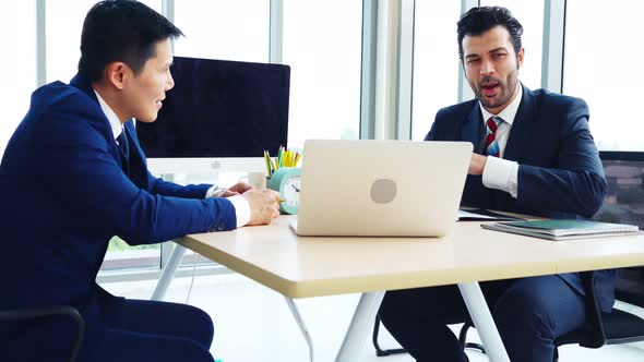 Two Business People Talk Project Strategy at Office