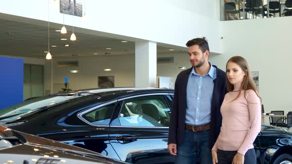 Young Couple Chooses Car at the Dealership