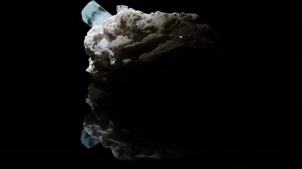 A single very clear crystal of aquamarine emerges from a feldspar matrix. Sample from Argentina.