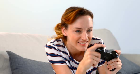 Woman playing joystick game on sofa