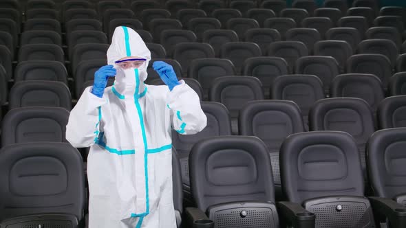 Disinfectant in Protective Suit Cleaning Cinema Hall