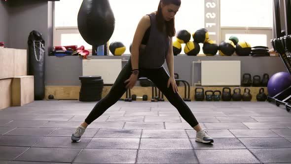 Young Beautiful Athletic Female Brunette Doiung Lunges Workout at the Gym