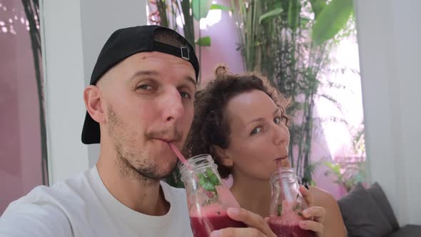 Cheerful Smiling Couple Drinking Healthy Detox Berries Smoothies After Sports and Jogging in the
