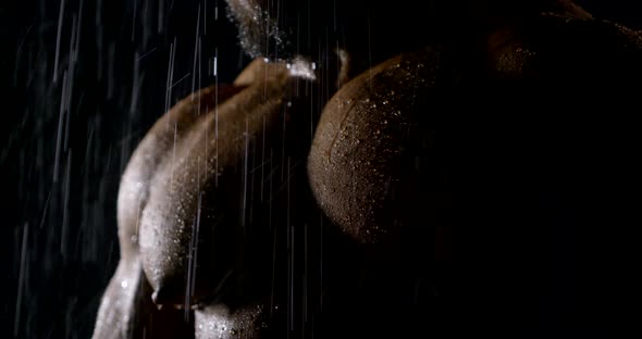 Naked Muscular Chest of Male Bodybuilder Standing Under Rain in Night Time, Closeup View