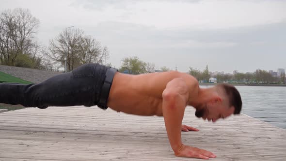 Muscular Man Doing a Pushup Exercise From the Floor Outdoors with a Naked Torso