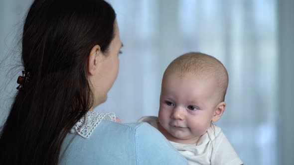 Young Mother Holding a Newborn Baby Boy in Her Arms