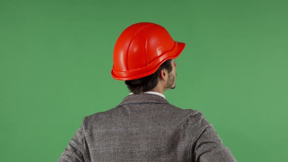 Rear View Portrait of a Contractor Wearing Hardhat Looking at the Green Screen