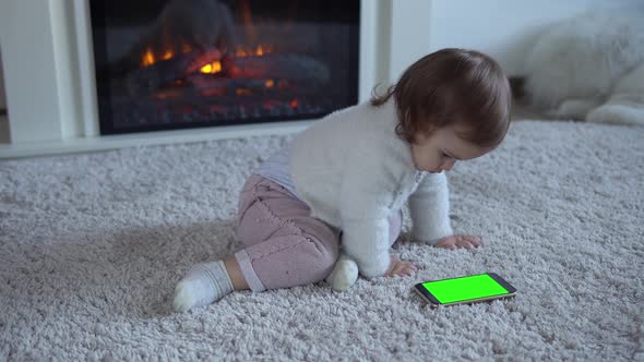 Adorable Cheerful Lucky Smart Toddler Baby Child Girl On Fluffy Carpet Using Smartphone Green Screen