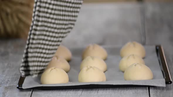 Woman makes homemade breakfast buns, Making buns. Dough on a baking tray