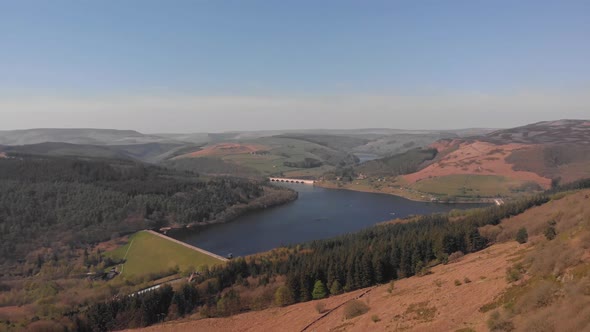 Drone travelling away from Lady Bower Reservoir Whilst panning down hiding Lady Bower Reservoir towa