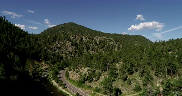 A short drone flight above a road nestled in the Rocky Mountains near Estes Park Colorado.