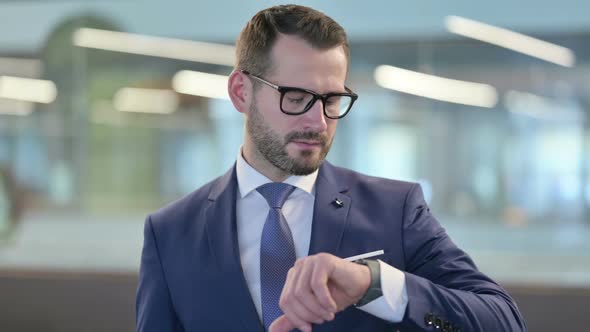 Portrait of Middle Aged Businessman Using Smartwatch