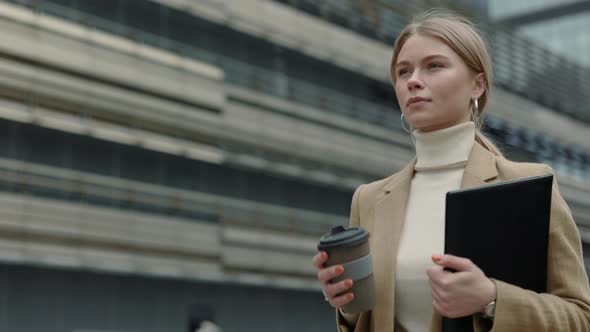 Business Lady Walking on Street with Clipboard and Coffee