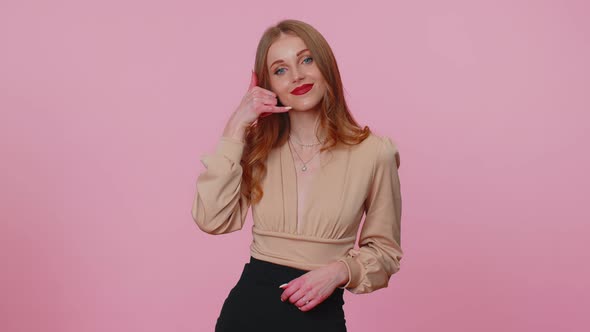 Cheerful Girl in Beige Blouse Looking at Camera Doing Phone Gesture Like Says Hey you Call Me Back