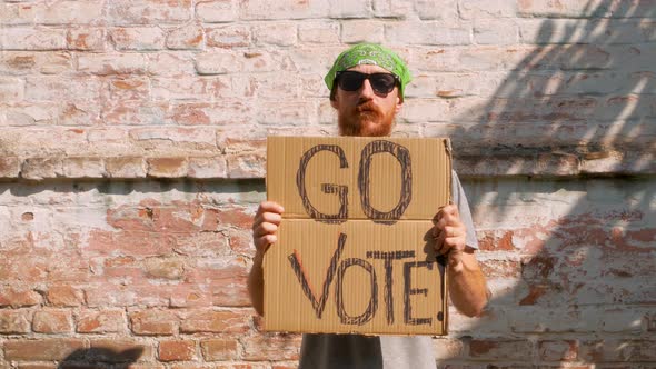 Man shows cardboard Go Vote sign Make the political choice Use your voice Presidential elections 4K